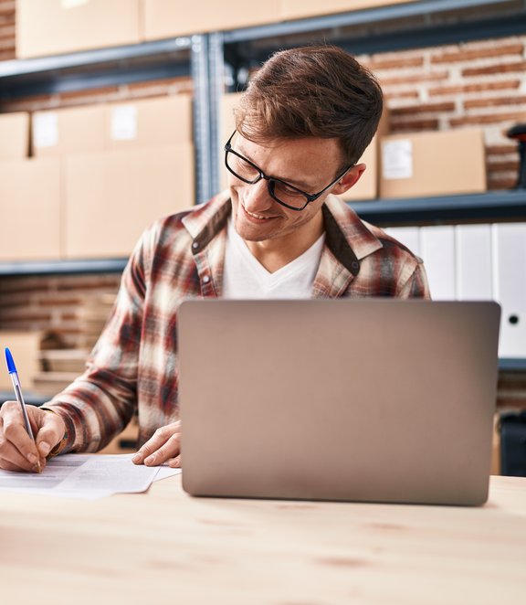Happy shop owner writing shipping details
