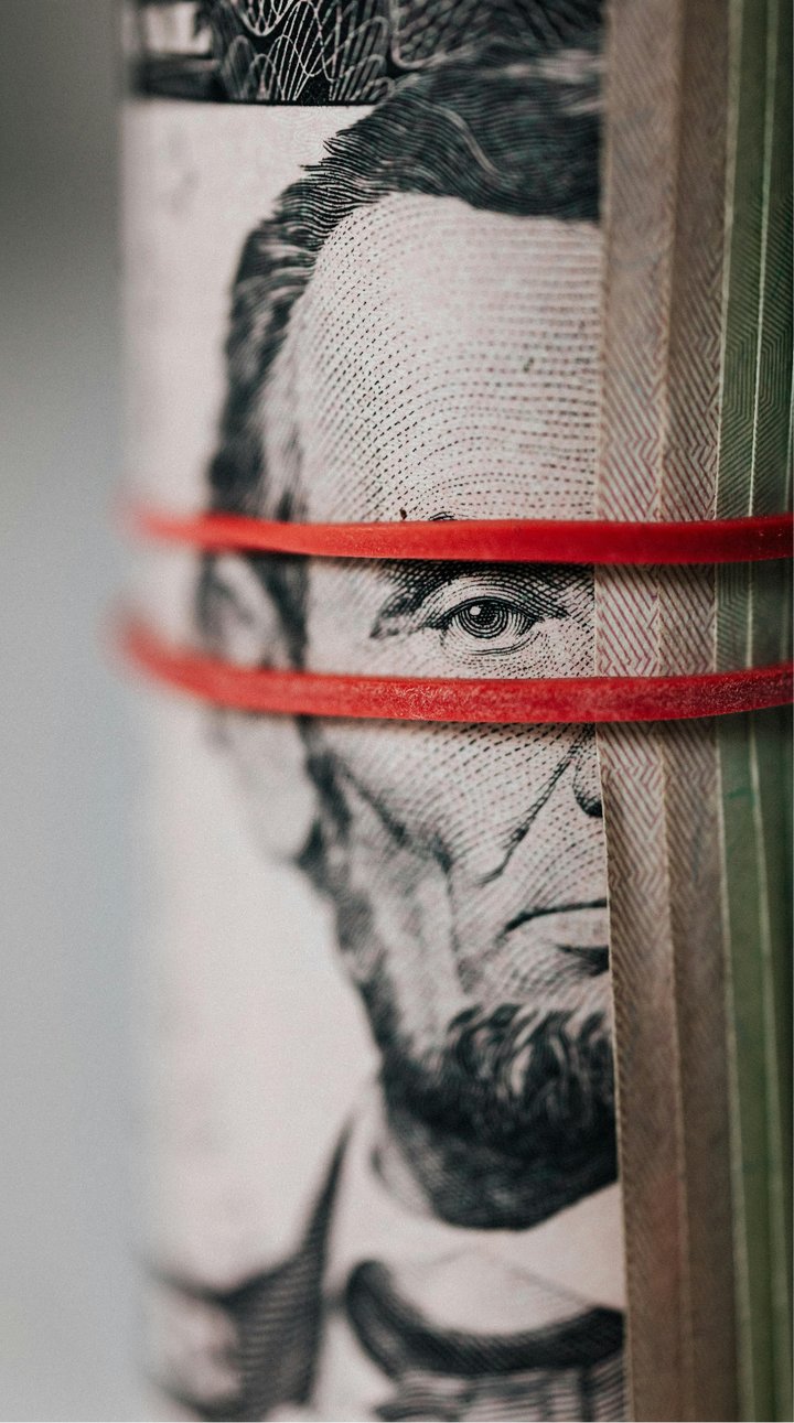 Roll of American dollar banknotes tightened with band