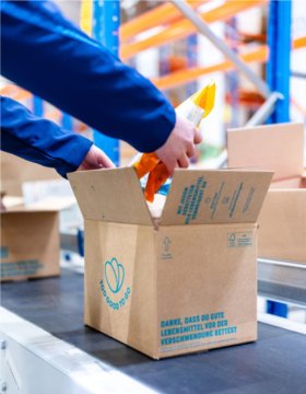 Person filling a Too good to go box