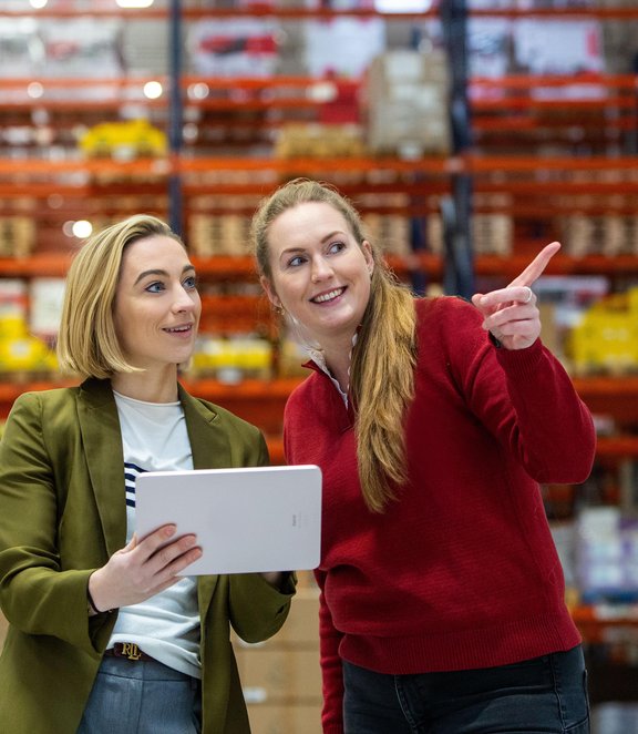 Daphne and Karolina in Operations smiling with tablet