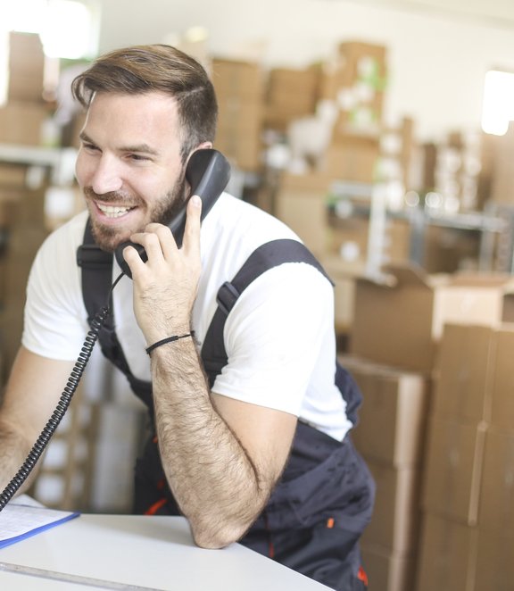 iStock - Jan 2021 - man on phone in warehouse - medium business - parcel - packing