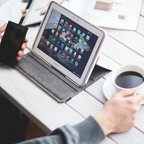 Man drinking coffee and using digital tablet